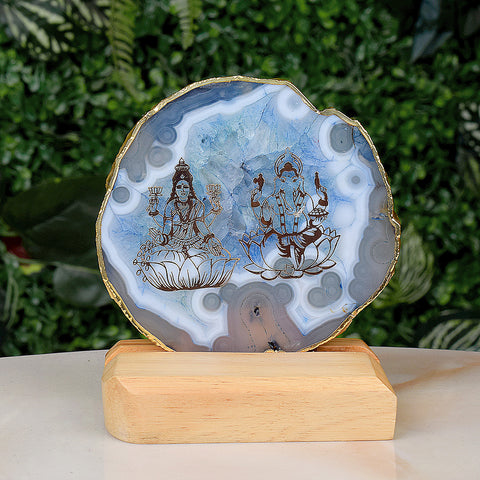 Agate stone stand featuring intricately carved Laxmi and Ganesha idols, mounted on a polished natural agate base for spiritual and decorative use. India’s Largest Pooja Accessories Brand – www.satvikstore.in