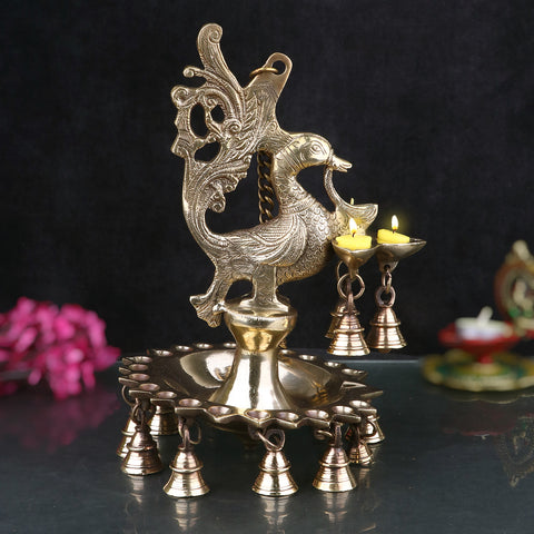 A stunning Brass Peacock Diya Hanging with Bells, featuring a graceful peacock design with a shiny brass finish.  India’s Largest Pooja Accessories Brand – www.satvikstore.in