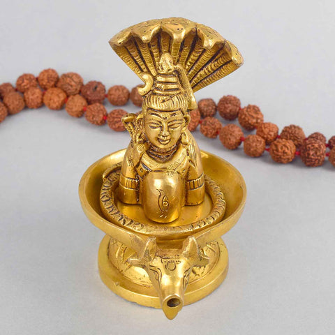 4.7 Inch Brass Shivalingam and Sheshnag Figurine showcasing Lord Shiva’s sacred lingam with the protective hood of Sheshnag — a divine symbol of power and cosmic energy. No.1 Brass Idol Store www.satvikstore.in 